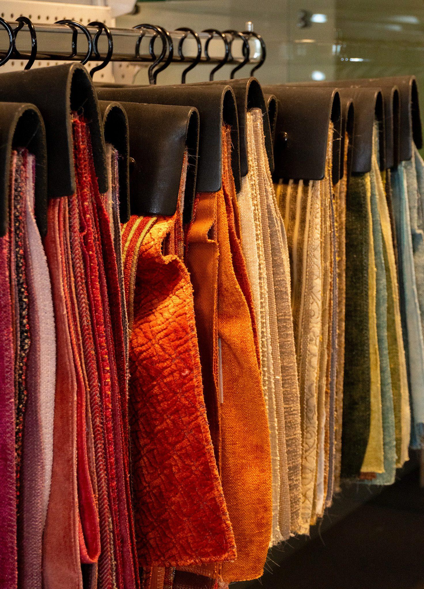 Stofstalen aan haken, in rood, oranje en andere kleuren
